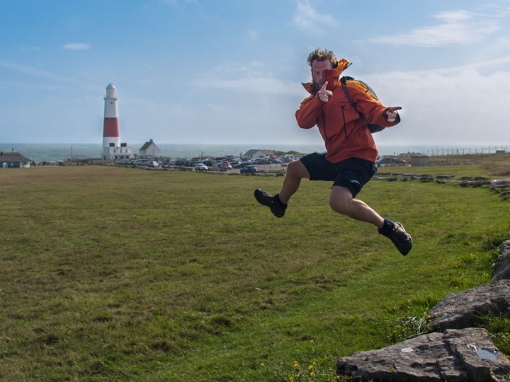 Darrell jumping in the air beside a coastal lighthouse